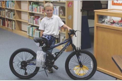 Ricky Friesen won the grand prize for the Kendrick Memorial Library summer reading program. To win the bike, names were gathered based on the number of times children came to read in the library and their reading logs, then a drawing was held. (Photo by L