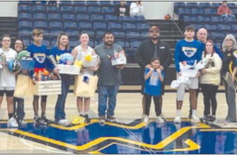 Wellman-Union seniors (from left) Becca Mixon, Jessica Lira, Alyssa Cavazos, Keagon Dominguez, Clayton Cochran and Kyler Neill are surrounded by family members after being recognized during a Senior Day celebration between games against Amherst on Friday 
