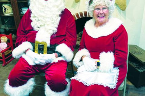 Guests take a moment to relax and visit in the home of Rustin and Kristin Knight Tuesday evening during the annual Home for the Holidays tour. Santa and Mrs. Claus smile for the camera, waiting for another family to arrive at the Terry County Museum Tuesd