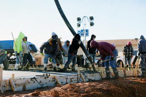 Construction workers begin pouring cement