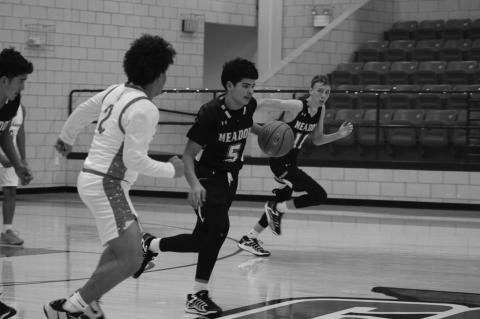 Meadow’s Esteban Estrada (5) moves up the court as Loop’s Bryson Hill (2) moves in to defend during a game at the Hermleigh Holiday Hoopapalooza on Thursday at Hermleigh High School.