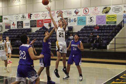 Wellman-Union’s Clayton Cochran (20) shoots over Amherst’s Joel Garcia (23) in a District 5-1A game on Friday at Wellman-Union High School. (LEE SCHEIDE|BROWNFIELD NEWS)