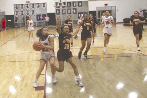 Brownfield’s Allyson Guzman (21) drives to the basket at Kermit’s Iris Lujan (10) defends during the first quarter of a Class 3A Division I bi-district playoff game on Monday at Klondike High School. (Photos by Lee Scheide | Brownfield News)