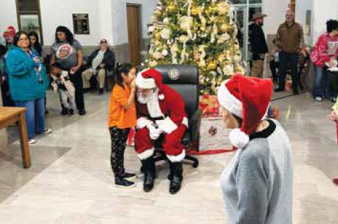 Guests wait patiently to listen to Santa Claus (Center) and then receive cookies afterward after the Christmas Light Parade.