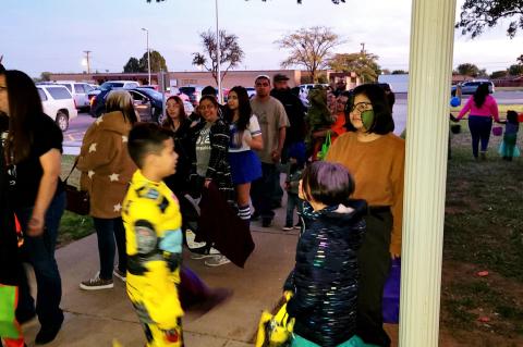 Kids and elders are lined up halfway to the street